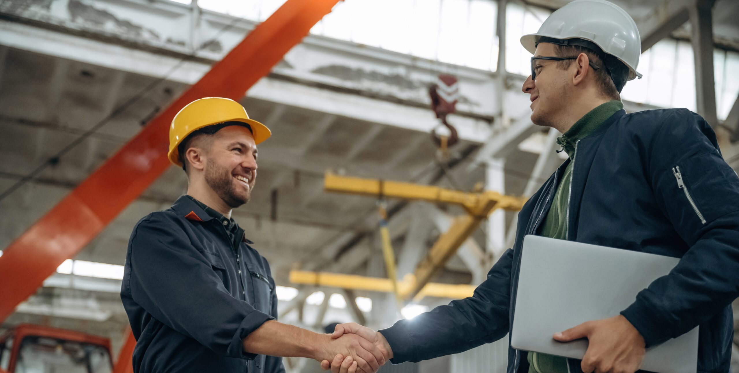 Preventieadviseur in gesprek met werknemer over veiligheid op de werkvloer in industriële omgeving